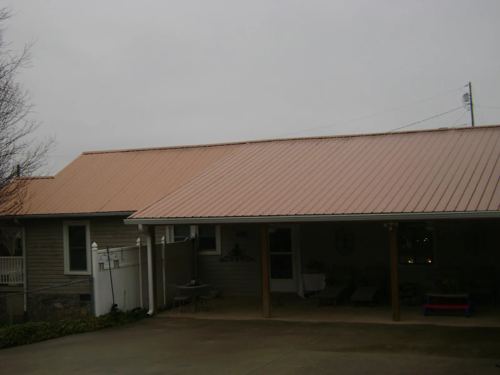 Copper toned metal roof over a wide covered patio in Margaret